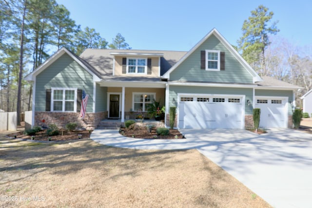 craftsman-style home featuring stone siding, covered porch, and concrete driveway