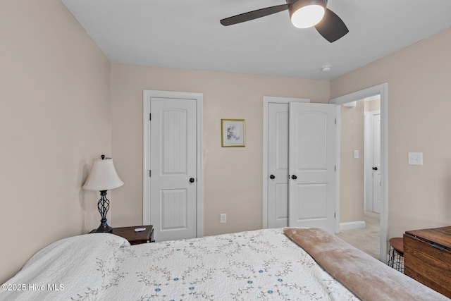 carpeted bedroom featuring baseboards and ceiling fan