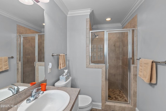 bathroom featuring vanity, toilet, a stall shower, and ornamental molding