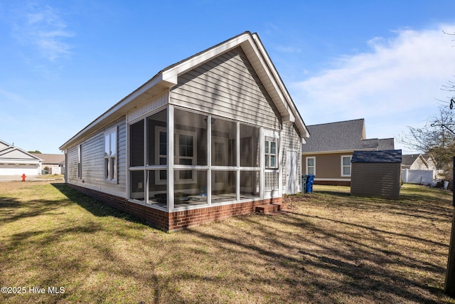 back of house with a lawn and a sunroom