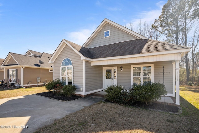 view of front facade with a front lawn and roof with shingles