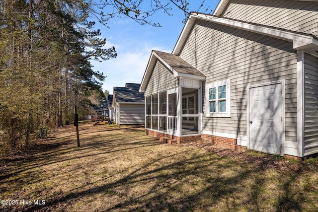 view of side of home with a lawn and a sunroom