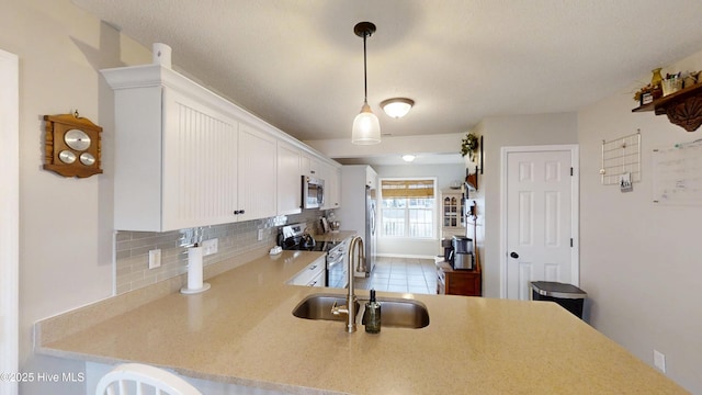 kitchen featuring a sink, decorative backsplash, light countertops, and stainless steel appliances