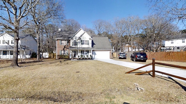 traditional home featuring fence, a residential view, concrete driveway, covered porch, and an attached garage