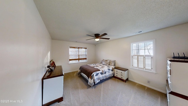 bedroom with multiple windows, visible vents, carpet floors, and a textured ceiling