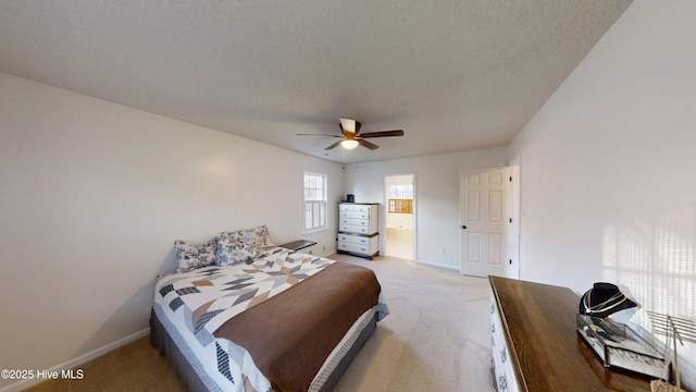 bedroom with light carpet, a ceiling fan, ensuite bathroom, and baseboards