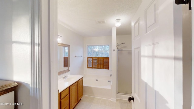 bathroom with a garden tub, a stall shower, vanity, and a textured ceiling