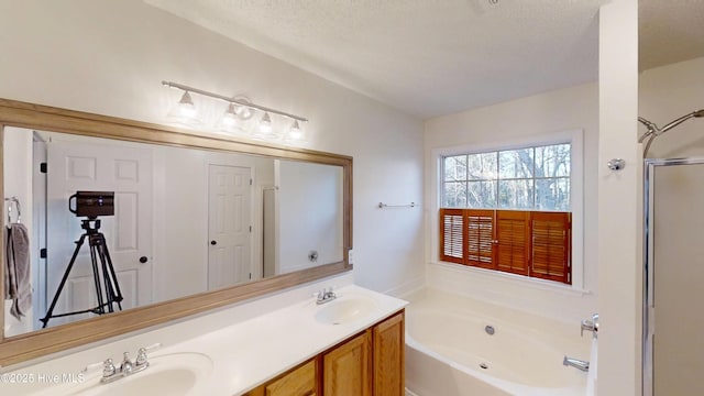 bathroom featuring a bath, double vanity, walk in shower, and a sink