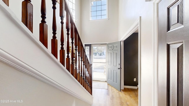 entryway featuring stairway, a high ceiling, wood finished floors, and baseboards