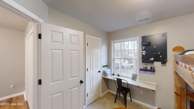 office area featuring visible vents, baseboards, a textured ceiling, and built in study area