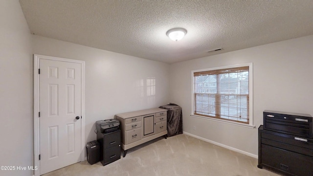 bedroom featuring visible vents, light colored carpet, a textured ceiling, and baseboards