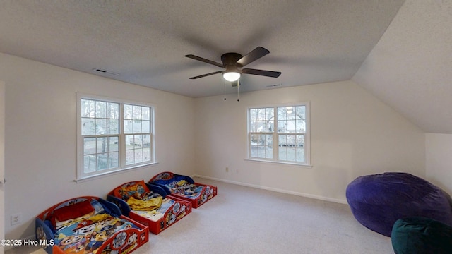 game room with visible vents, a textured ceiling, carpet, baseboards, and vaulted ceiling