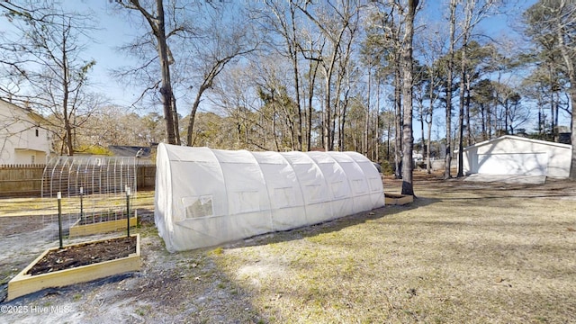 view of outdoor structure featuring an outbuilding, a garden, and fence