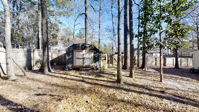 view of yard with a fenced backyard, a storage shed, and an outdoor structure