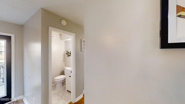 bathroom featuring toilet and baseboards