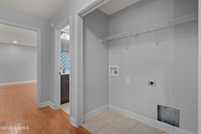 126 Lightwater Dr, Aberdeen, NC 28315 - washroom with washer hookup, laundry area, baseboards, light wood-type flooring, and hookup for an electric dryer