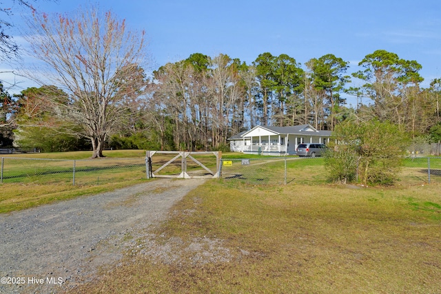 exterior space with a front yard, a gate, fence, and driveway