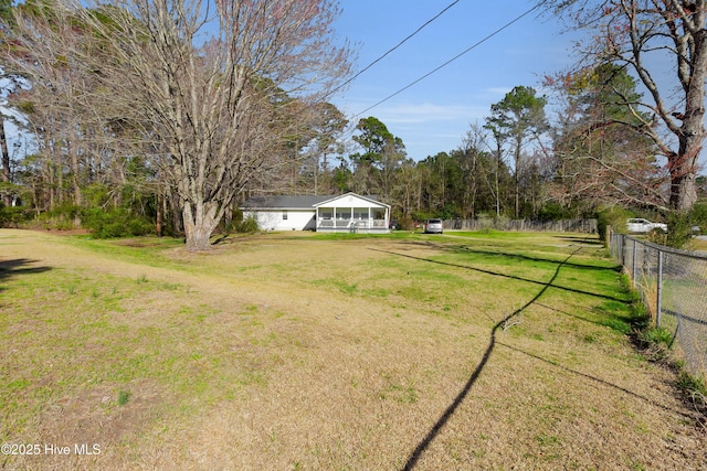 view of yard with fence and a sunroom