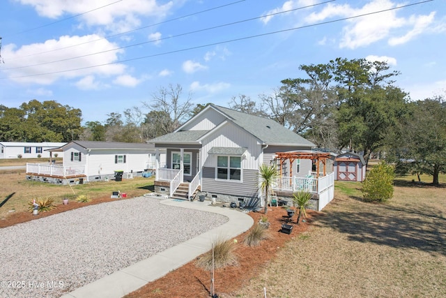 view of front of property with a front lawn, roof with shingles, covered porch, crawl space, and a pergola