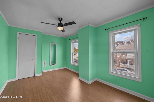 209 N 8th St, Morehead City, NC 28557 - unfurnished bedroom featuring wood finished floors, ornamental molding, baseboards, and a ceiling fan