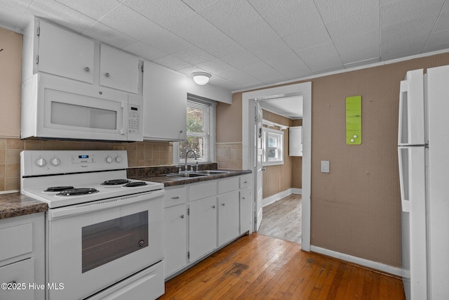 209 N 8th St, Morehead City, NC 28557 - kitchen with white appliances, a sink, dark countertops, light wood-style flooring, and backsplash