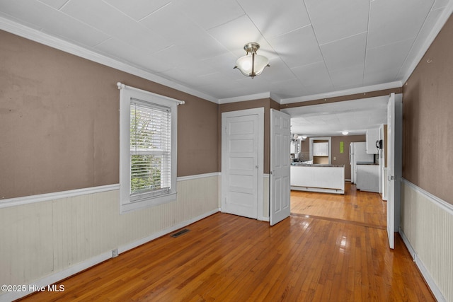 209 N 8th St, Morehead City, NC 28557 - spare room featuring light wood-style flooring, wainscoting, and ornamental molding