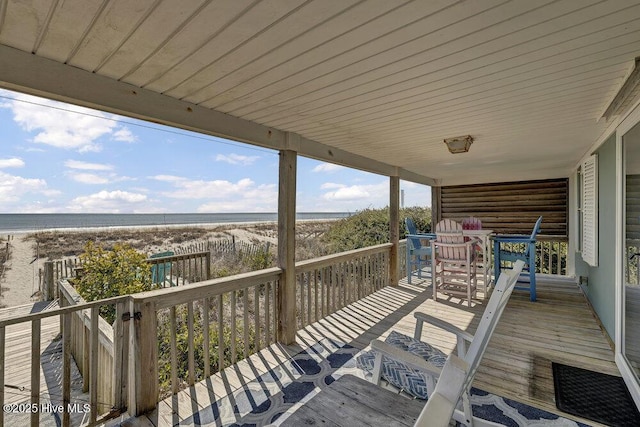 deck featuring a beach view and a water view