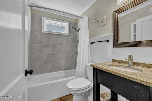 full bath featuring tile patterned flooring, toilet, shower / bath combo with shower curtain, wainscoting, and vanity