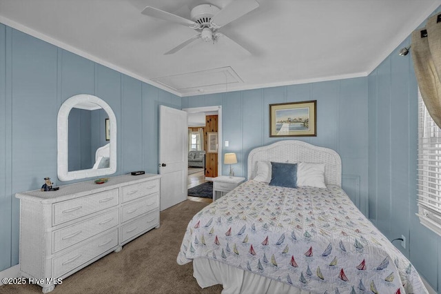 bedroom featuring attic access, a decorative wall, dark colored carpet, and ceiling fan