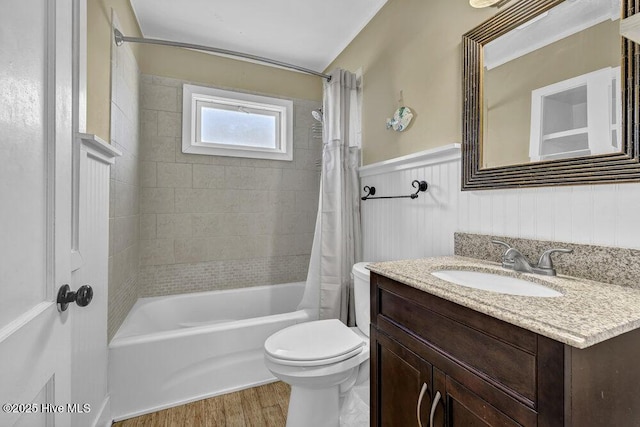 full bath with a wainscoted wall, toilet, shower / bath combo, wood finished floors, and vanity