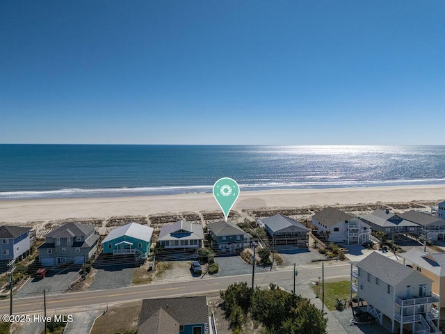 drone / aerial view featuring a view of the beach, a residential view, and a water view