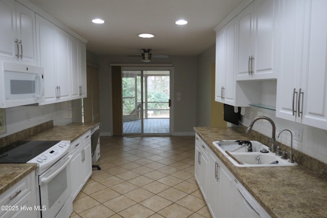 kitchen with a sink, white appliances, white cabinets, light tile patterned floors, and decorative backsplash