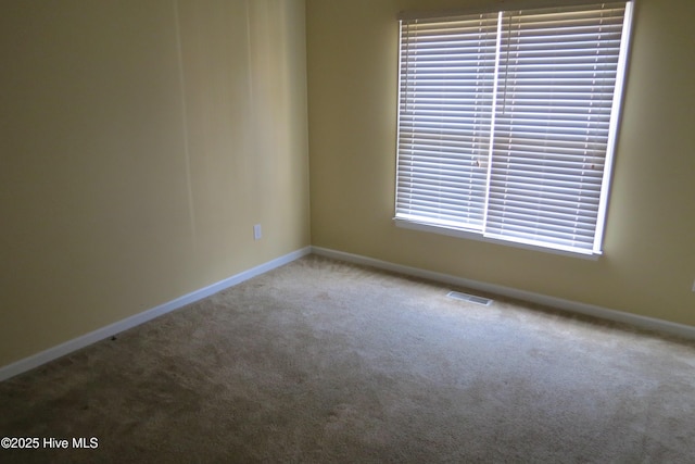 carpeted spare room with visible vents and baseboards