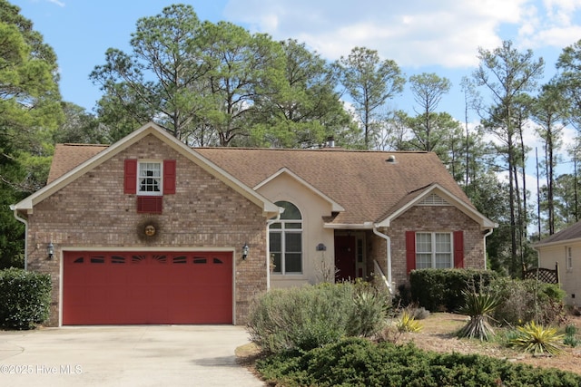 view of front facade featuring brick siding, driveway, and a shingled roof