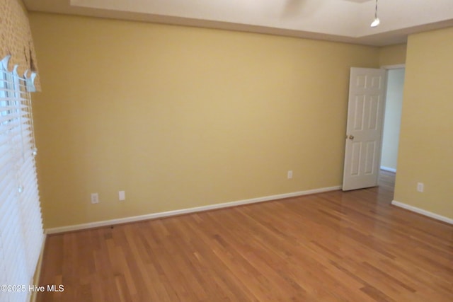 unfurnished room with baseboards and light wood finished floors