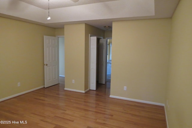 unfurnished bedroom with light wood-type flooring and baseboards