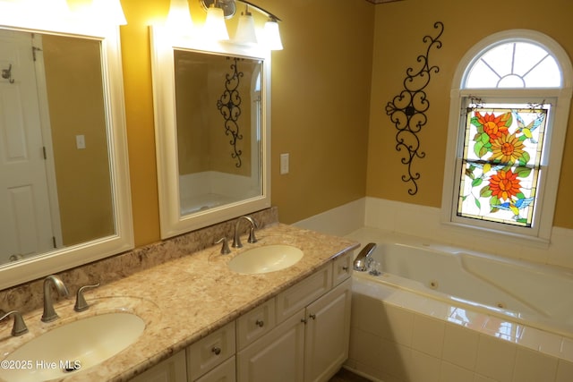 bathroom featuring a sink, a tub with jets, and double vanity