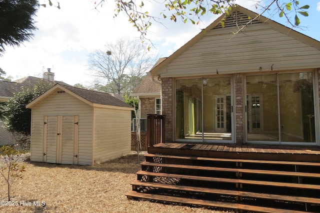 rear view of house featuring an outbuilding, a shed, and brick siding