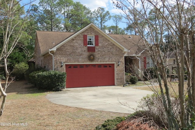 view of front of house with brick siding, concrete driveway, a front yard, roof with shingles, and a garage