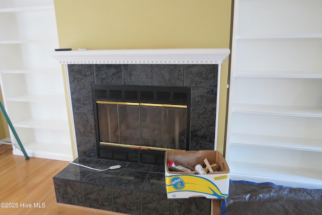 room details with a tiled fireplace and wood finished floors