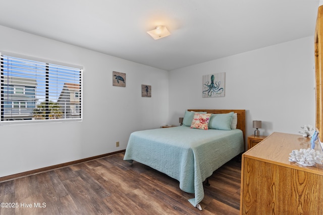 bedroom featuring baseboards and dark wood-style flooring