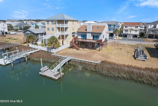 exterior space with a residential view, a deck with water view, and stairs