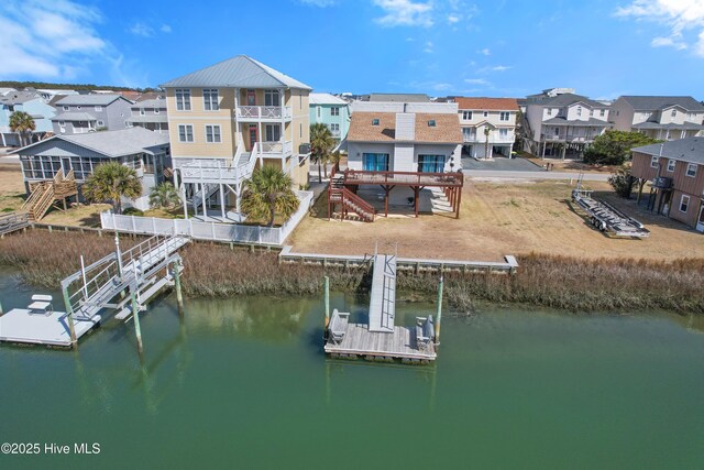 dock area featuring stairs, a residential view, and a water view