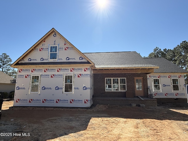 property in mid-construction featuring brick siding