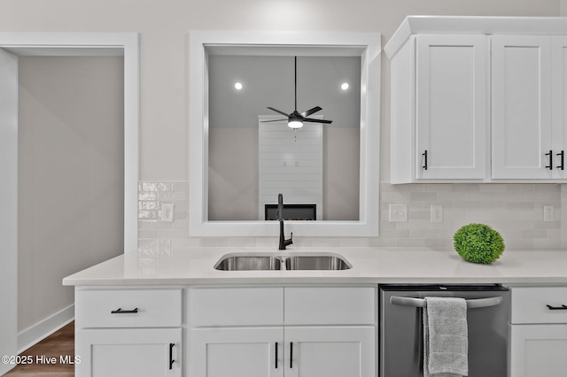 kitchen featuring white cabinets, dishwasher, light countertops, and a sink