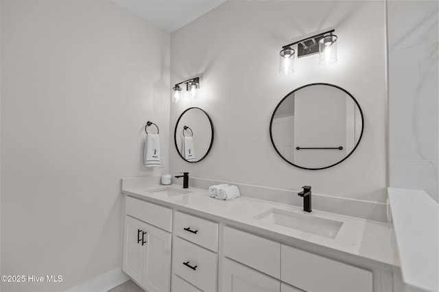 full bathroom featuring double vanity, baseboards, and a sink