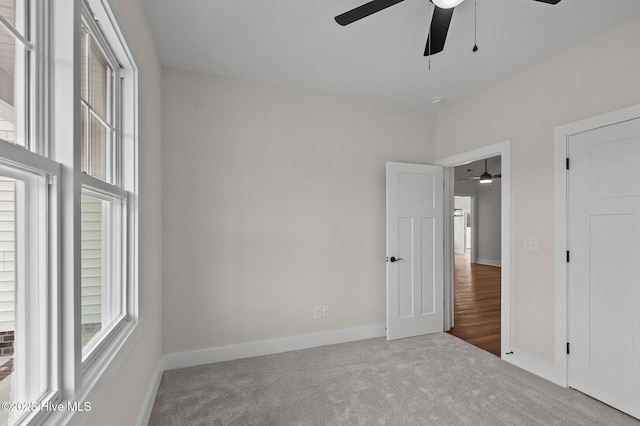 unfurnished bedroom with carpet, baseboards, and ceiling fan