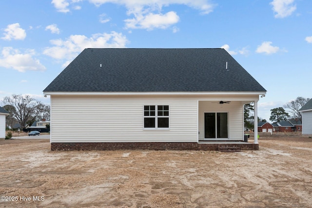 back of property with ceiling fan and a shingled roof