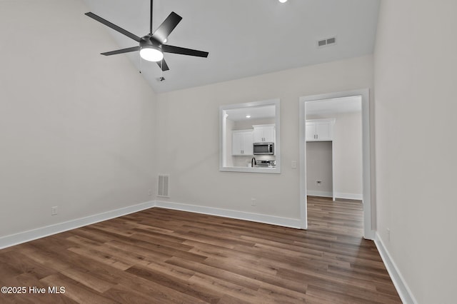 spare room with dark wood-style floors, visible vents, ceiling fan, and baseboards