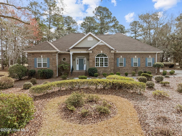 view of front of home with brick siding and a shingled roof